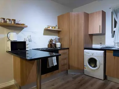 a kitchen with a washing machine and a washer at A home away from home cosy luxurious compact 1 bed in Centurion