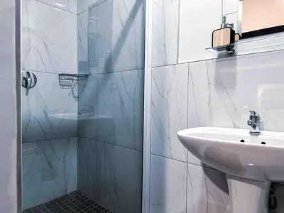 a white bathroom with a shower and a sink at A home away from home cosy luxurious compact 1 bed in Centurion