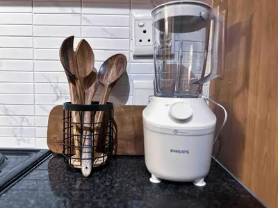 a blender sitting on top of a counter with wooden spoons at A home away from home cosy luxurious compact 1 bed in Centurion