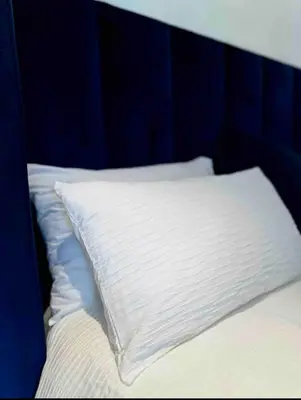 a bed with a white pillow on top of it at A Private Room with a Private Entrance in Olifantsfontein