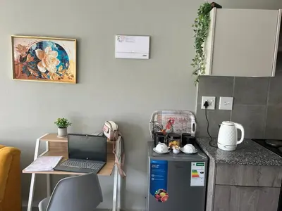 a kitchen with a laptop on top of a refrigerator at Gwendolen in Pretoria