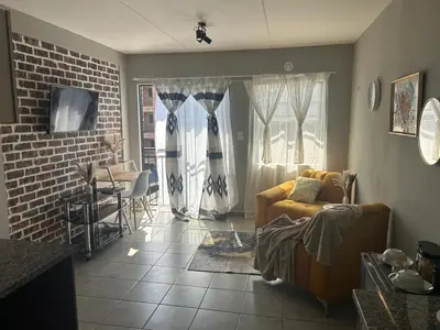 a living room with a couch and a table at Gwendolen in Pretoria