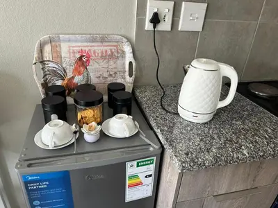 a kitchen counter with a coffee maker and a chicken on it at Gwendolen in Pretoria