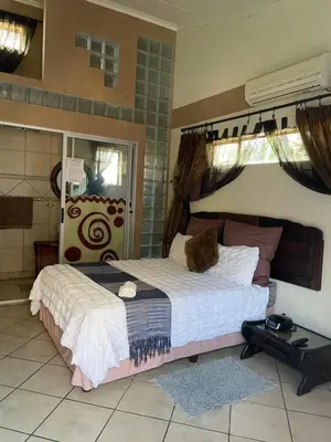 a bedroom with a large bed in a room at Texas Guesthouse in Phalaborwa