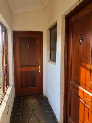 an empty hallway with a wooden door and a window at Cherry Lane at Cherry Grove in Dullstroom