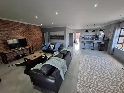 a large living room with a couch and a kitchen at The Goose Guesthouse in Dullstroom