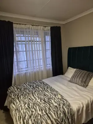 a bedroom with a zebra print bed with a window at Peace at 68 in Nelspruit