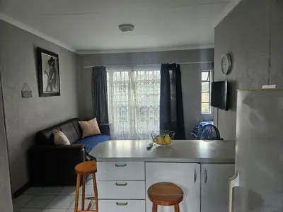 a kitchen and living room with a couch at Peace at 68 in Nelspruit
