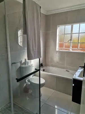 a bathroom with a toilet and a bath tub at Lovely 2 Bedroom Townhouse with private garden in Centurion