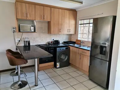 a kitchen with a stainless steel refrigerator and a dishwasher at Lovely 2 Bedroom Townhouse with private garden in Centurion