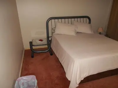 a bedroom with a bed and a night stand next to it at Pilot Inn Accommodation in Kempton Park