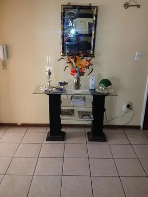 a table in a room with a mirror and flowers on it at Pilot Inn Accommodation in Kempton Park
