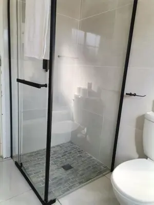 a shower with a glass door in a bathroom at The Reeds Private Garden House in Centurion