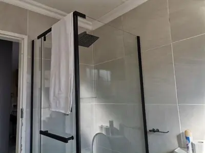a shower with a glass door in a bathroom at The Reeds Private Garden House in Centurion