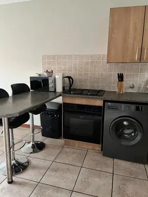 a kitchen with a stove and a washing machine at The Reeds Private Garden House in Centurion