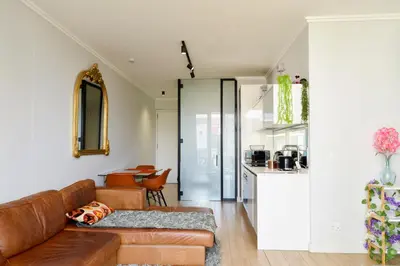 a living room with a couch and a kitchen at Luxury Escape at Ellipse 1-Bed, Kitchen, Wi-Fi & Free Parking in Midrand