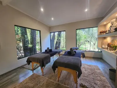 a room with four beds and large windows at Karongwe - Kuname Safari Lodge in Hoedspruit