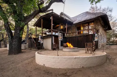a house with a fire pit in front of it at Karongwe - Kuname Safari Lodge in Hoedspruit