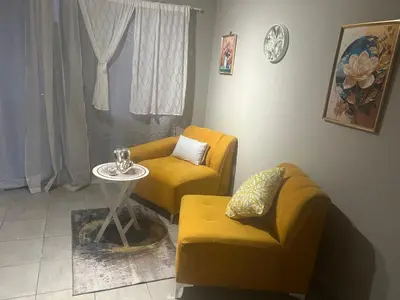 a living room with two chairs and a table at Cosy Apartment in Pretoria