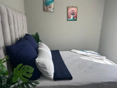 a bed with blue and white pillows in a bedroom at Cosy Apartment in Pretoria
