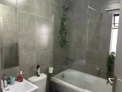 a bathroom with a tub and a toilet and a sink at Cosy Apartment in Pretoria