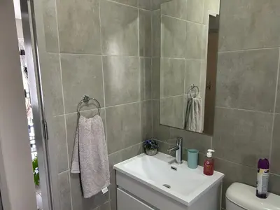 a bathroom with a sink and a toilet and a mirror at Cosy Apartment in Pretoria