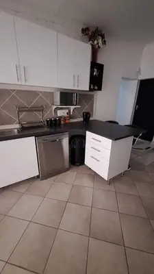 a kitchen with white cabinets and a black counter top at Casa Maya in Pretoria