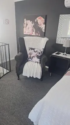 a bedroom with a chair and a pillow and a desk at Casa Maya in Pretoria