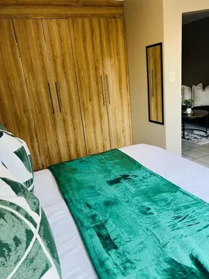 a bedroom with a bed with a green blanket on it at Apartment with stunning scenic views in Pretoria