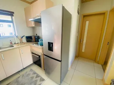 a stainless steel refrigerator in a small kitchen at Phoenix Rising Apartment in Midrand
