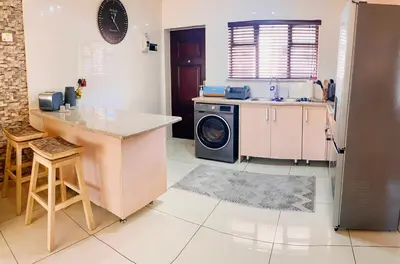 a kitchen with a washing machine and a counter at Phoenix Rising Apartment in Midrand