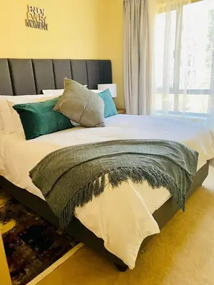 a bedroom with a large bed with a large window at Phoenix Rising Apartment in Midrand