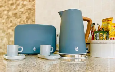 a blue coffee pot and two cups on a counter at Phoenix Rising Apartment in Midrand