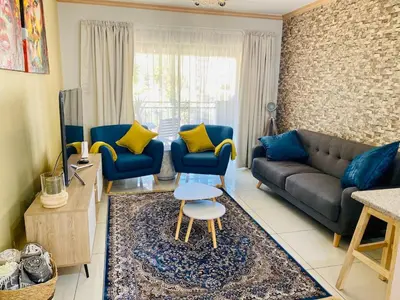 a living room with a couch and chairs and a table at Phoenix Rising Apartment in Midrand