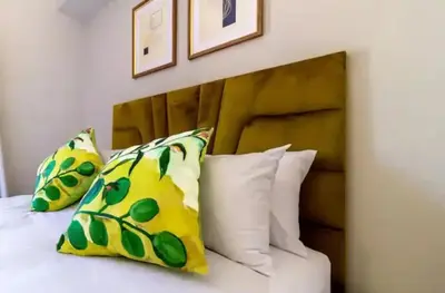a bedroom with a bed with pillows and a wooden headboard at #AlimamaSpaces The Rob's Polofields in Midrand