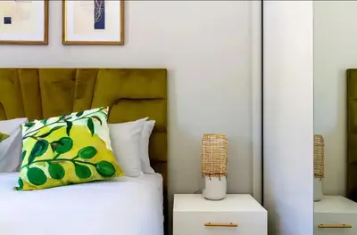 a bedroom with a bed with a yellow and green pillow at #AlimamaSpaces The Rob's Polofields in Midrand