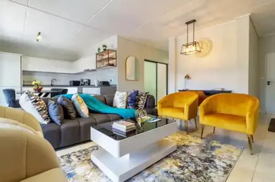 a living room with a couch and a table at #AlimamaSpaces The Rob's Polofields in Midrand