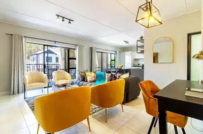 a living room with a couch and a table at #AlimamaSpaces The Rob's Polofields in Midrand