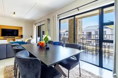 a dining room with a table and chairs at #AlimamaSpaces The Rob's Polofields in Midrand