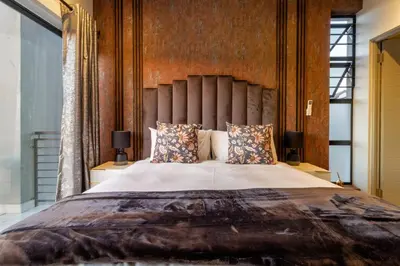 a bedroom with a large bed with a large headboard at AlimamaSpacesThe Mansons Cascades Villa in Midrand