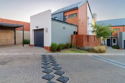 a brick parking lot with stepping stones in front of a building at AlimamaSpacesThe Mansons Cascades Villa in Midrand