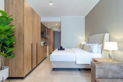 a hotel room with a bed and a couch at AlimamaSpaces The Noxy Menlyn Maine in Pretoria