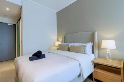 a bedroom with a white bed with a black bag on it at AlimamaSpaces The Noxy Menlyn Maine in Pretoria
