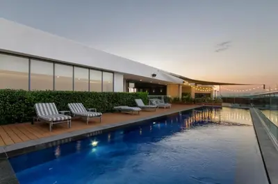 a building with a swimming pool in front of a building at AlimamaSpaces The Noxy Menlyn Maine in Pretoria