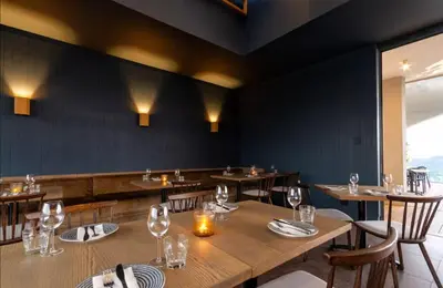 a dining room with wooden tables and chairs at AlimamaSpaces The Noxy Menlyn Maine in Pretoria