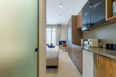 a room with a bed and a kitchen with a bed gmaxwell gmaxwell gmaxwell at AlimamaSpaces The Noxy Menlyn Maine in Pretoria