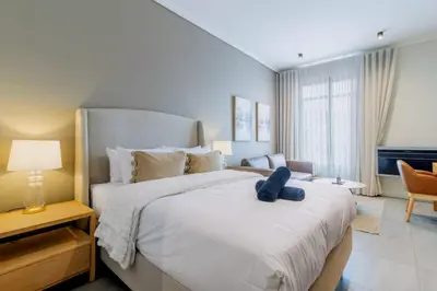 a bedroom with a large bed with a blue teddy bear on it at AlimamaSpaces The Noxy Menlyn Maine in Pretoria