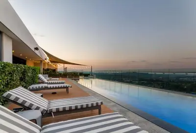 a building with a balcony with a swimming pool at AlimamaSpaces The Noxy Menlyn Maine in Pretoria