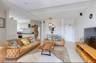 a living room with a couch and a table at AlimamaSpaces Semandi Polofields in Midrand