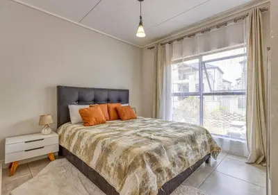 a bedroom with a bed and a large window at AlimamaSpaces Semandi Polofields in Midrand